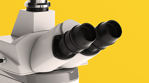 Close up of white microscope on a yellow background