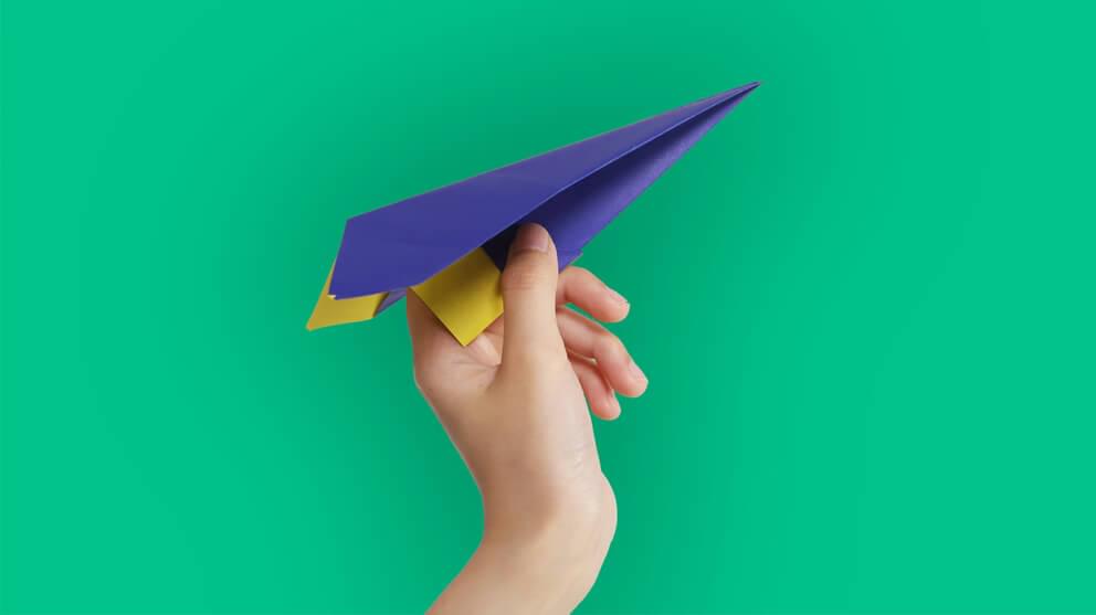 Hand Holding Blue Paper Airplane