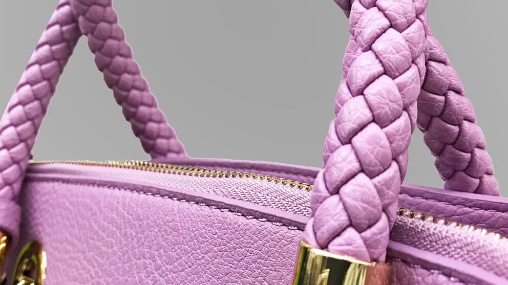 Pink handbag Close-Up on braided handles and metal accessories