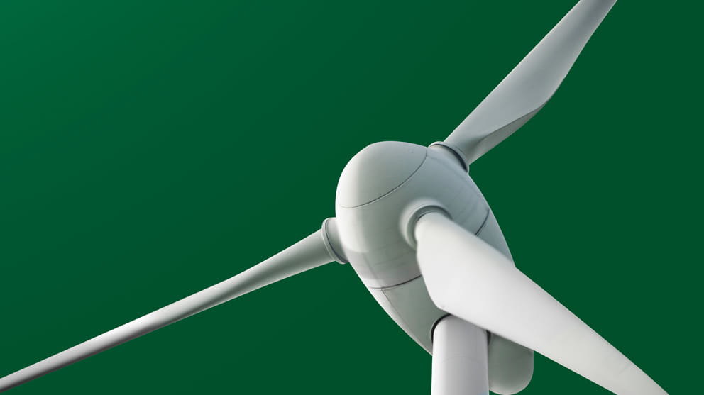 White wind turbine on green background