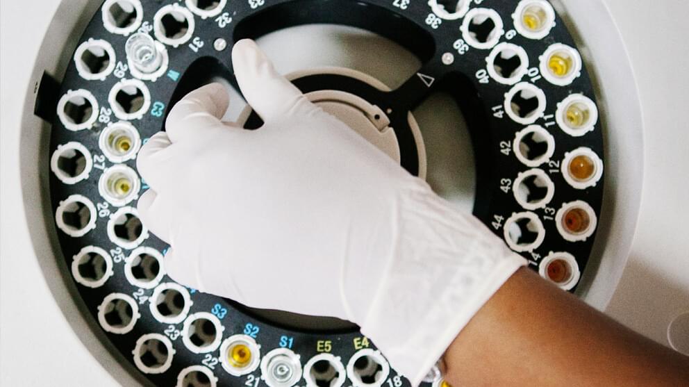 Overhead view of scientist using centrifuge machine